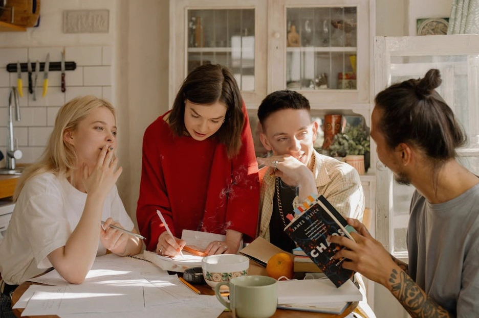A couple sitting at a kitchen table, smiling while reviewing their household budget on a tablet.