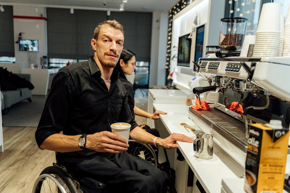 A person paying for a cup of coffee with a contactless card at a cafe.